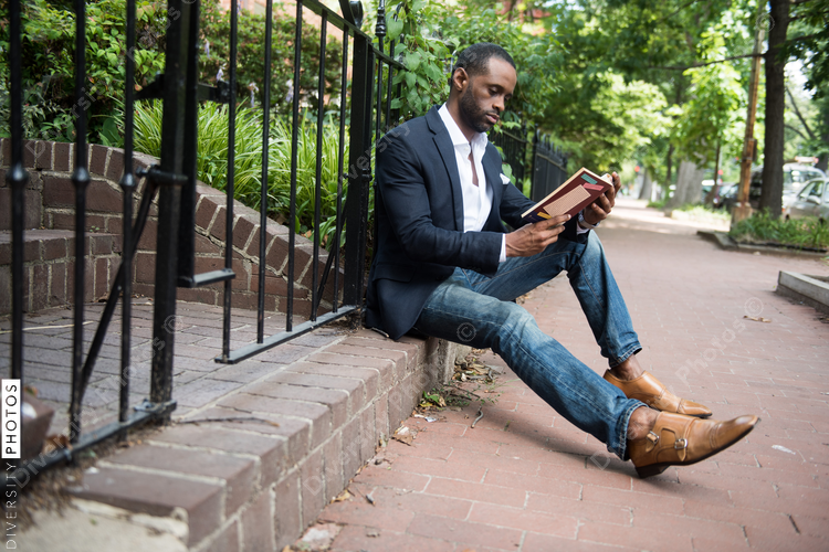 Businessman reading book while sitting outdoors