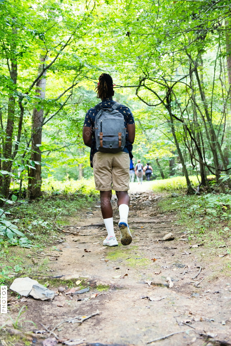 Man walks up hiking trail