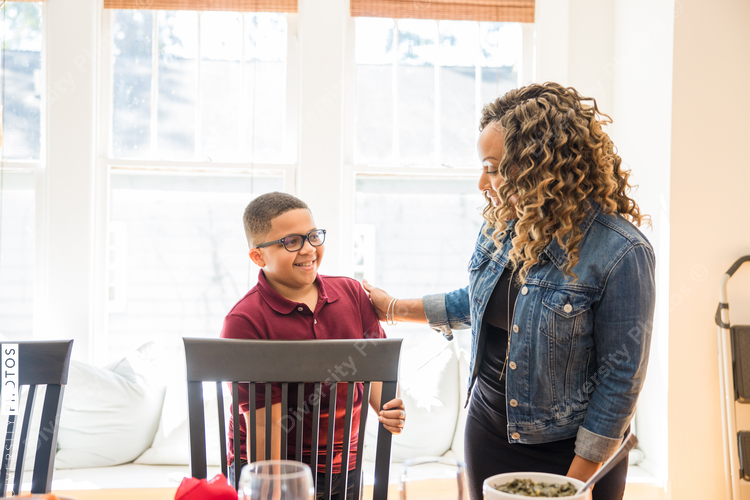 Black son pulls chair out for his mother