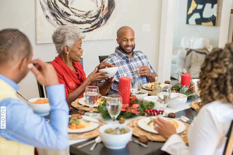 Black family eating Christmas dinner together at dining room table