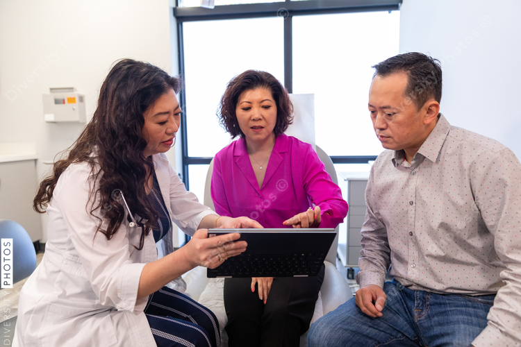 Asian doctor consulting patients in medical exam room