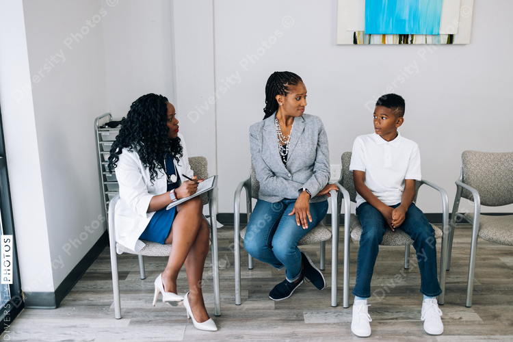 Black doctor consulting mother and son patients