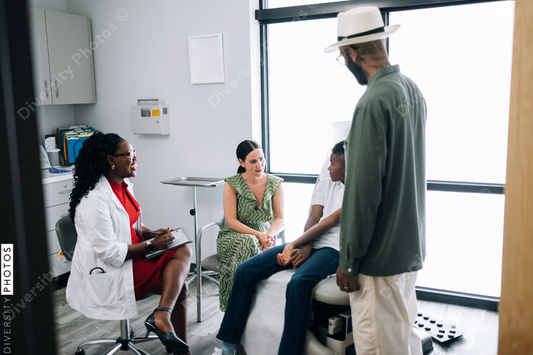 Black doctor consulting mixed race family at local physician practice