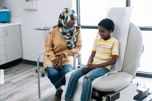 Black Muslim mother and son waiting in doctors office
