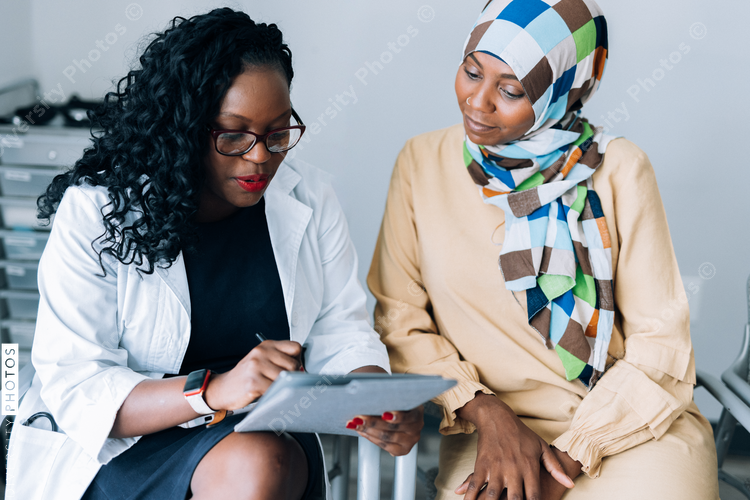 Doctor consulting Muslim patient wearing hijab