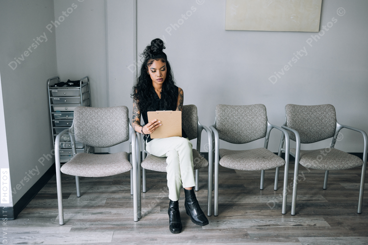 Mixed Race woman filling out paperwork at doctors office