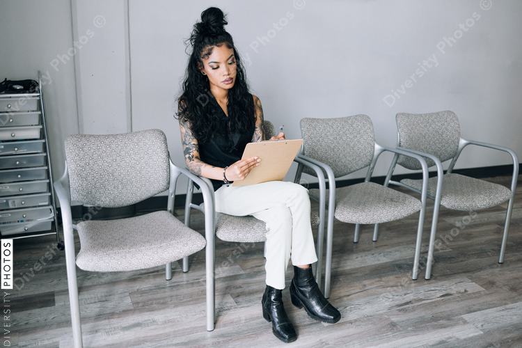 Mixed Race woman filling out paperwork at doctors office
