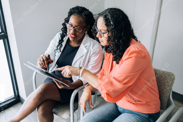 African American doctor consulting female Hispanic patient