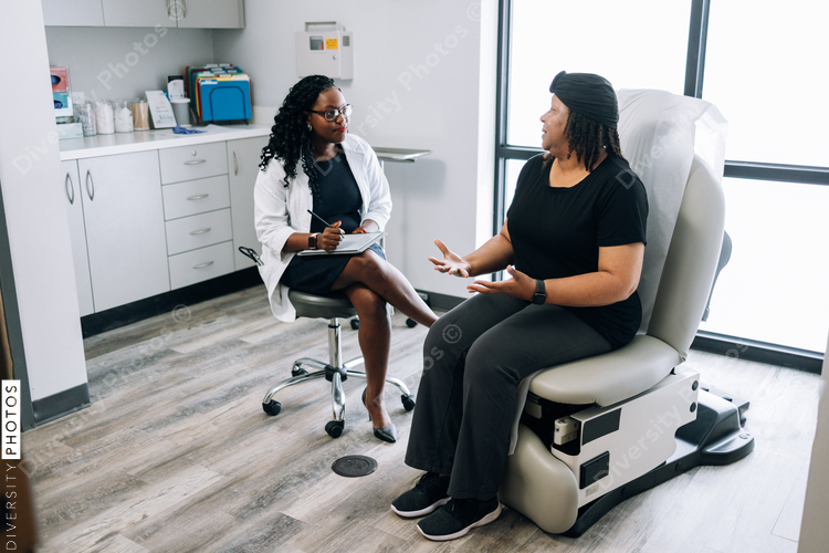 Black female doctor consults woman with head covering