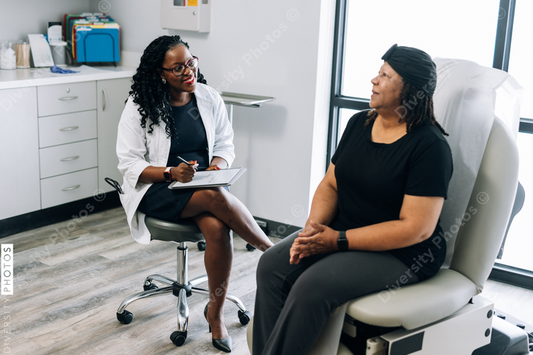 Black female doctor consults woman with head covering