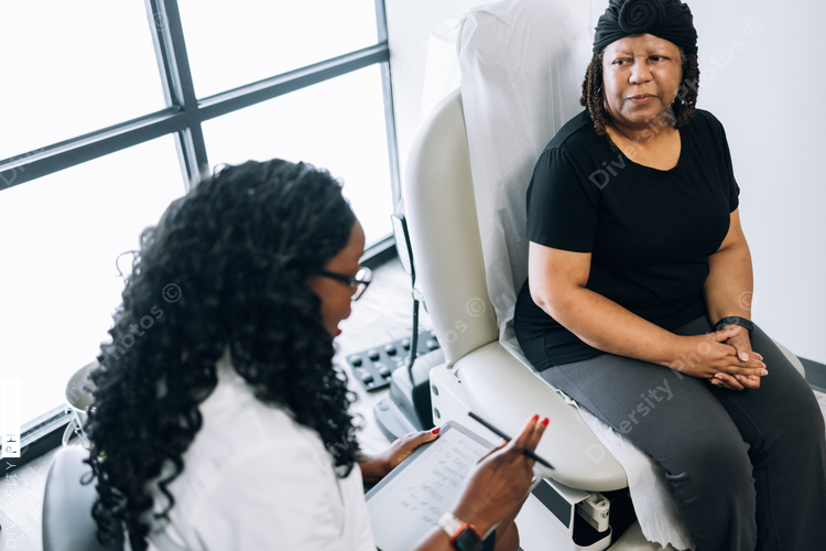 Black female doctor consults woman with head covering