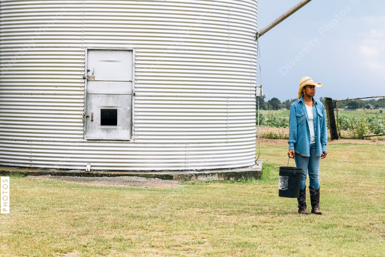 Woman standing near corn and grain storage house