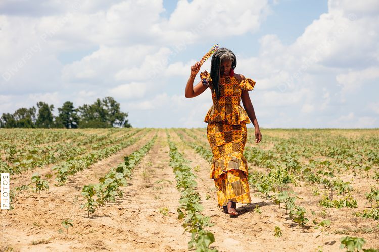 Woman walking cotton field in pretty African dress