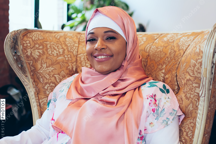 Portrait of woman wearing hijab sitting in armchair