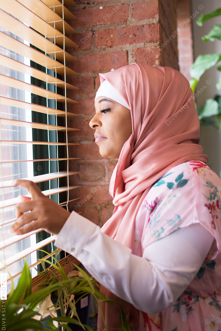 Side view of woman looking out through window
