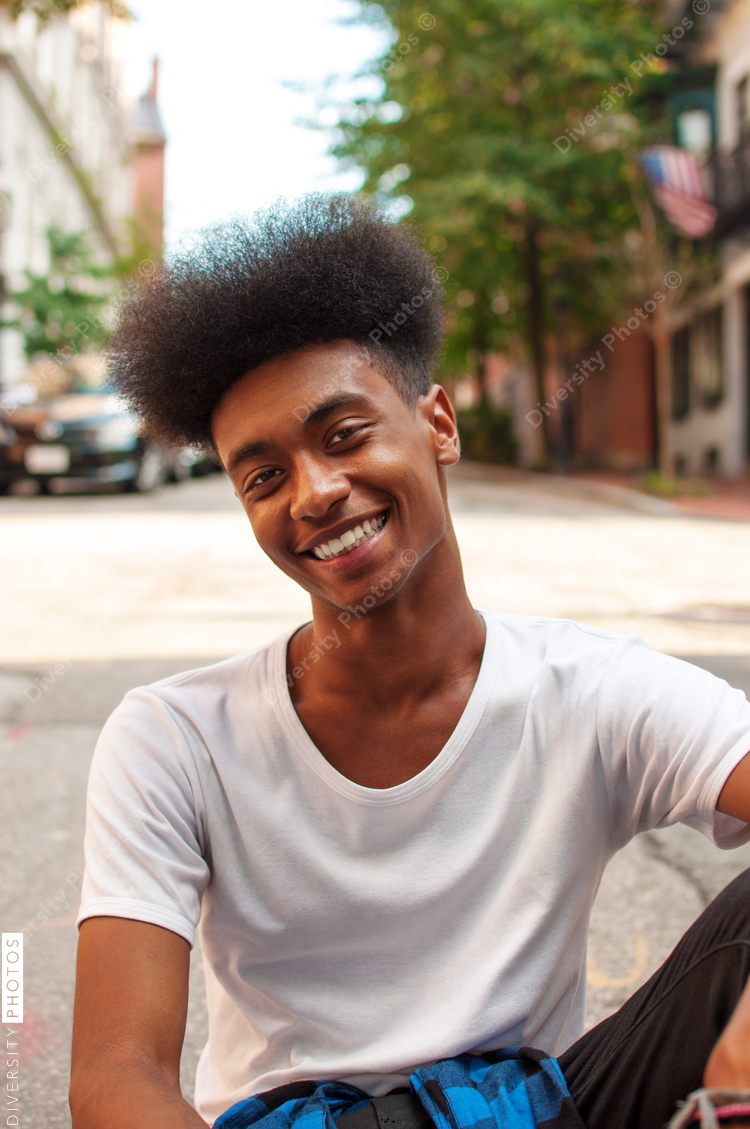 Portrait of young man sitting on street