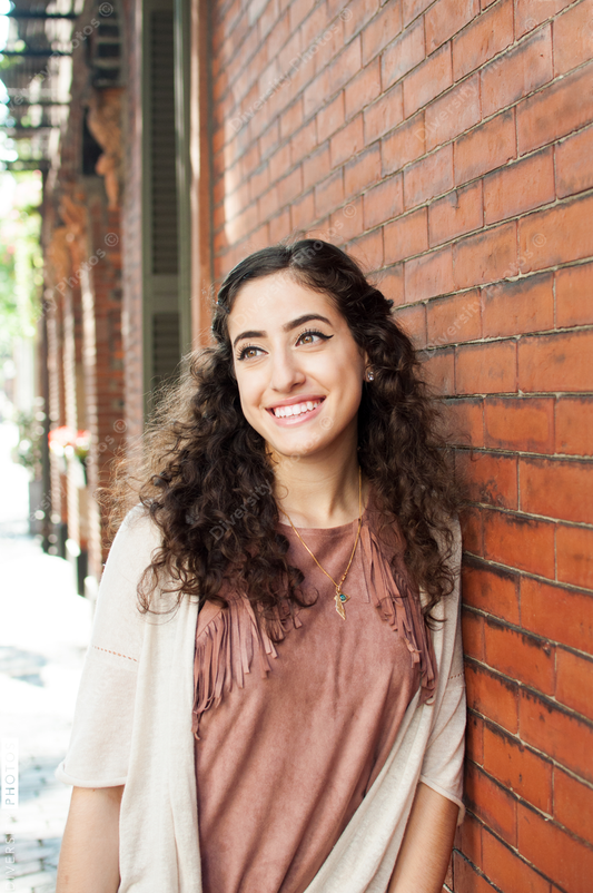 Young woman leaning on brick wall