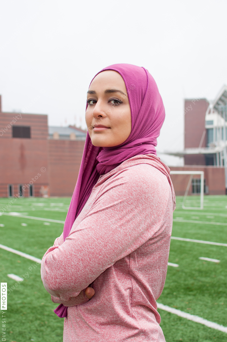 Portrait of young woman standing on soccer field