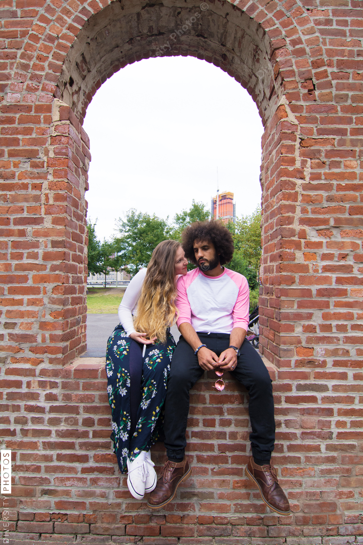 Couple sitting on arch wall 