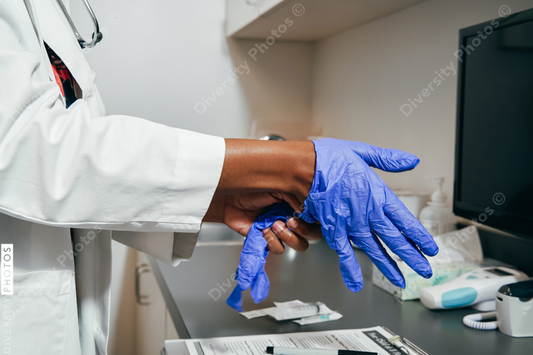 Black Doctor using rubber gloves, close up of hands