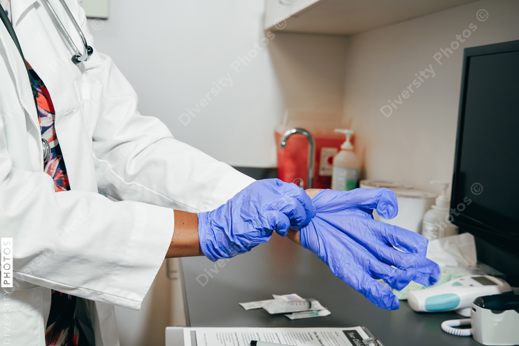 African American Doctor using rubber gloves, close up of hands