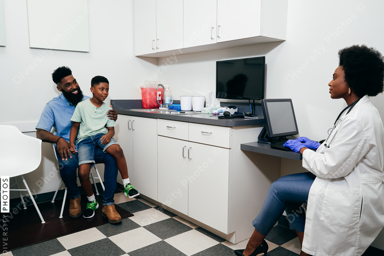 Black woman Pediatrician¬†with patients in her office