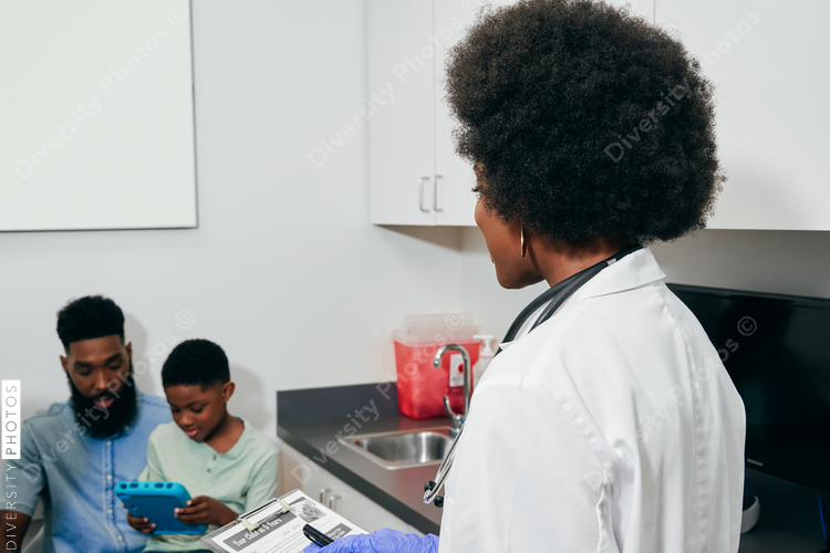 Black woman Pediatrician¬†with patients in exam room