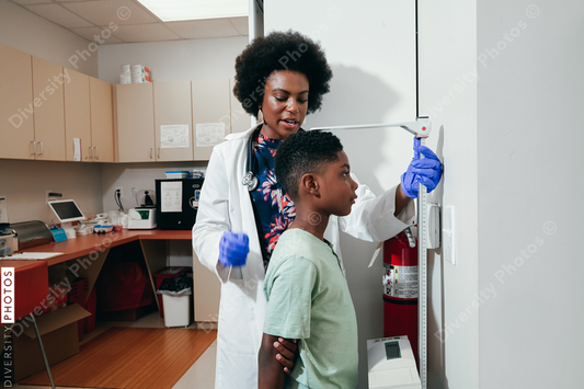 Black Pediatrician¬†measuring patient's height