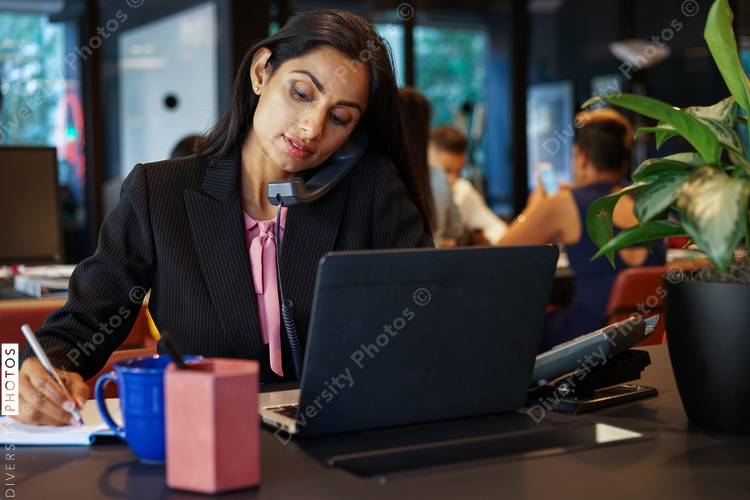 Businesswoman talking on telephone while working in office