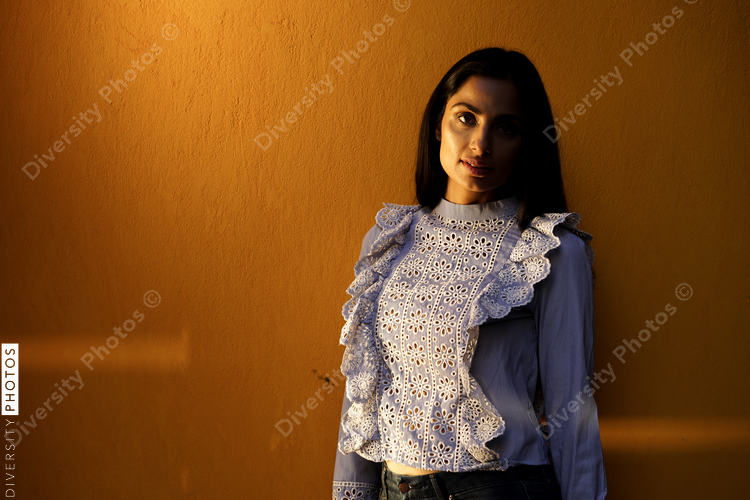 Portrait of woman standing against yellow background