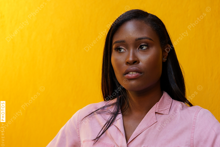 Portrait of brunette woman against yellow wall
