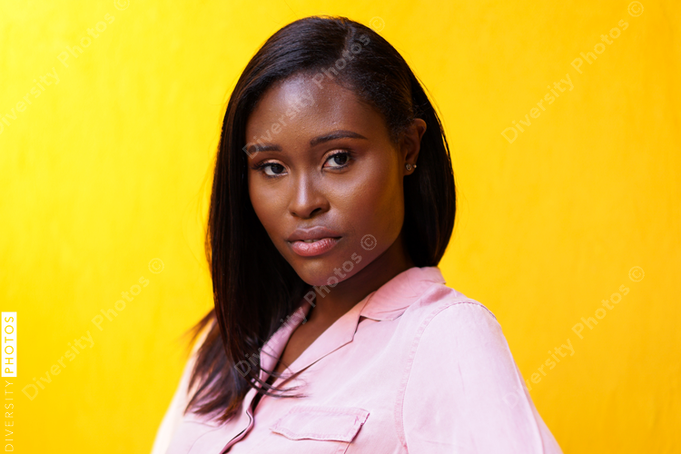 Portrait of brunette woman against yellow wall