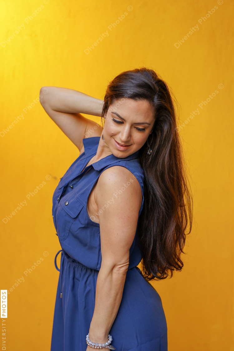 Smiling woman standing against yellow background