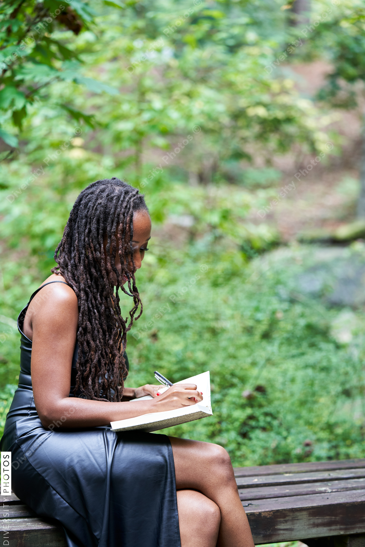 Portrait of Black woman reading and journaling