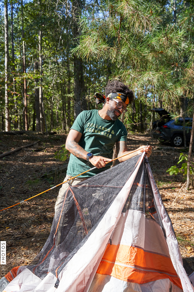 Black man setting up camping tent