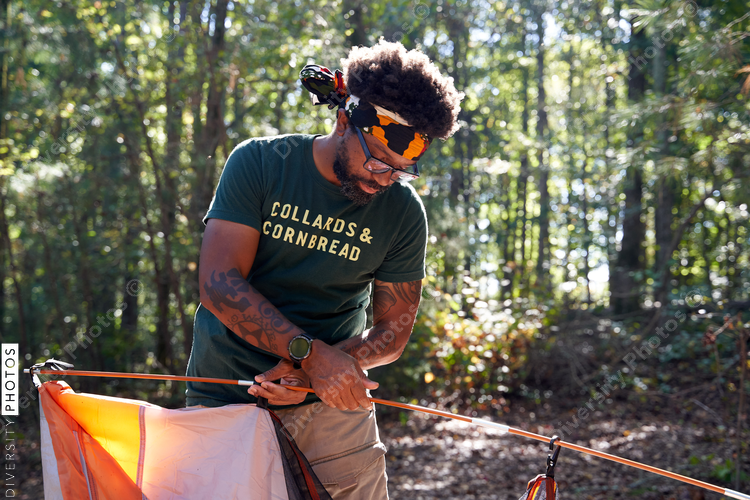 Black man setting up camping tent