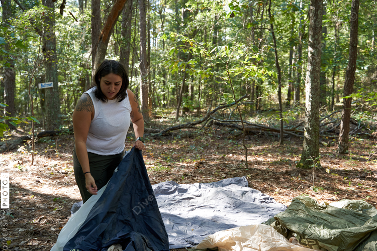Woman sets up camping gear at campsite