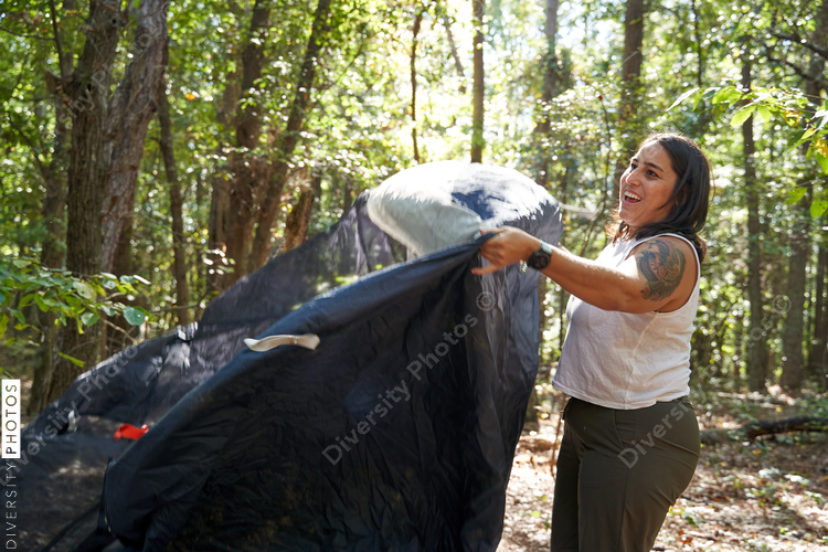 Woman sets up camping gear at campsite