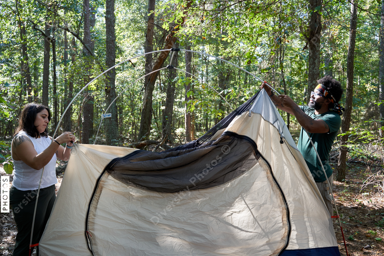 Friends setting up tent at campsite