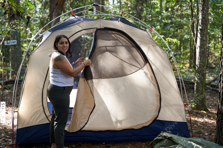 Woman sets up camping gear at campsite