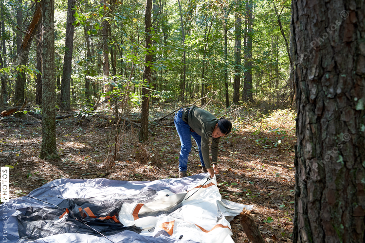 Black woman setting up tent at campsite trip