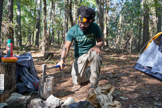 Black man chopping wood for campfire