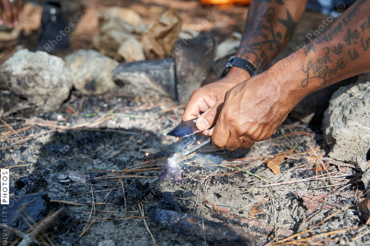 Man lights fire for campfire at campsite