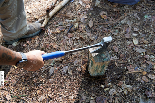 Black man chopping wood for campfire