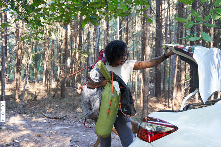 Black woman unloads car for camping trip vacation