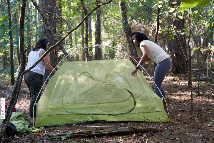 Friends setting up tent at campsite