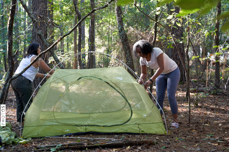 Friends setting up tent at campsite