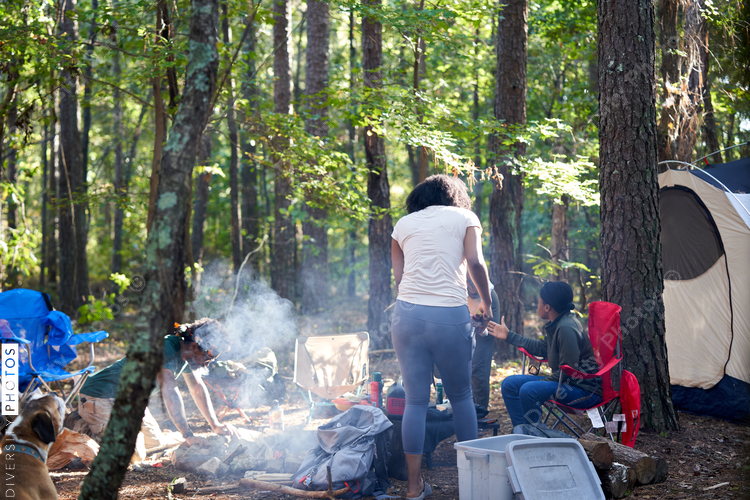 Friends enjoying weekend getaway, relaxing at campsite in woods