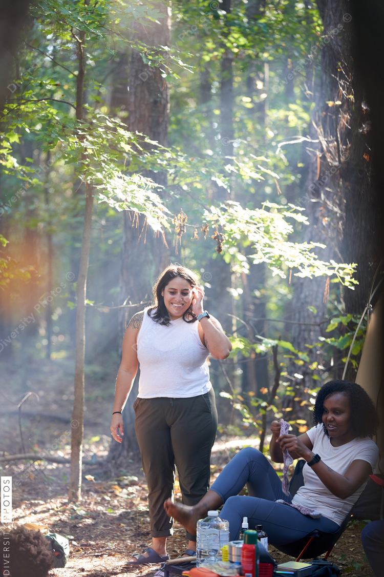 Friends enjoying weekend getaway, relaxing at campsite in woods