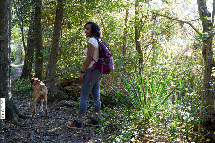 Black woman exploring nature outdoors with pet dog